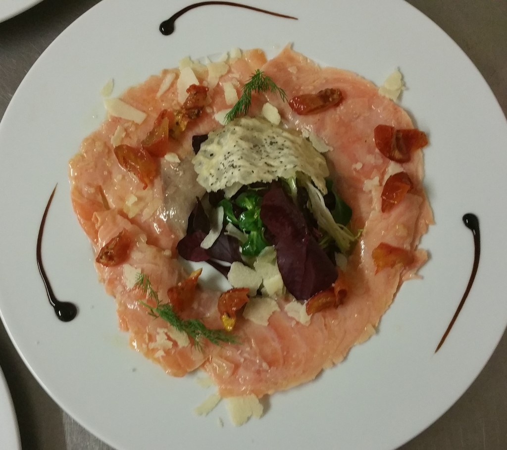 Le carpaccio de saumon, salade folle et copeaux de parmesan